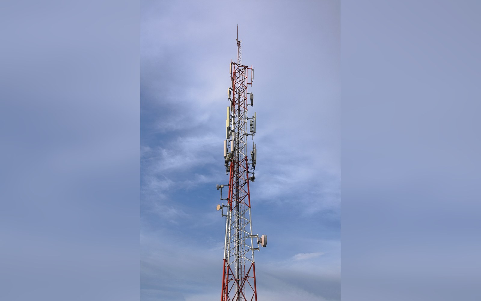 A cell site headframe against flat overcast sky