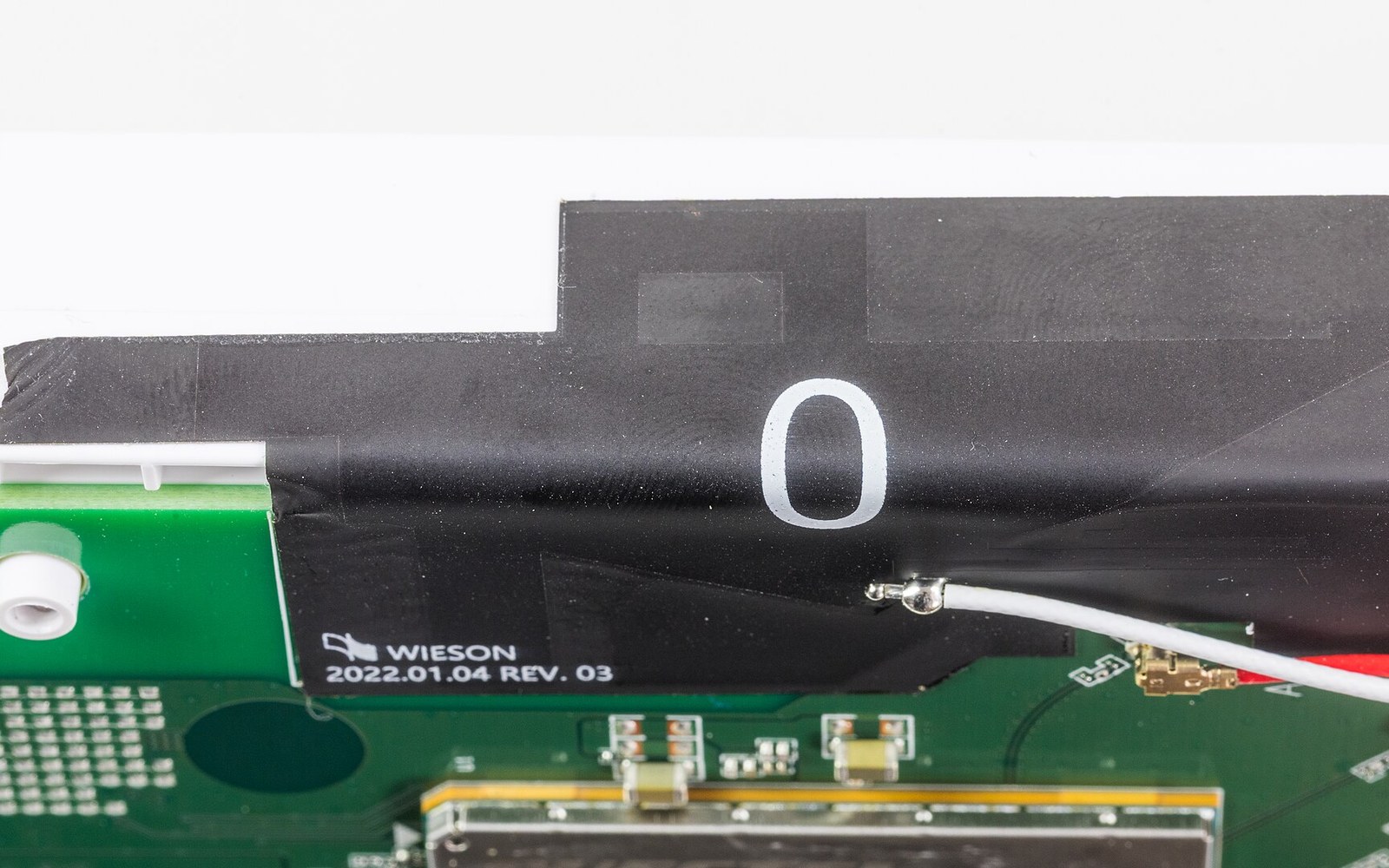 Black antenna cable taped to a green circuit board labeled Wieson 2022.01.04 rev. 03